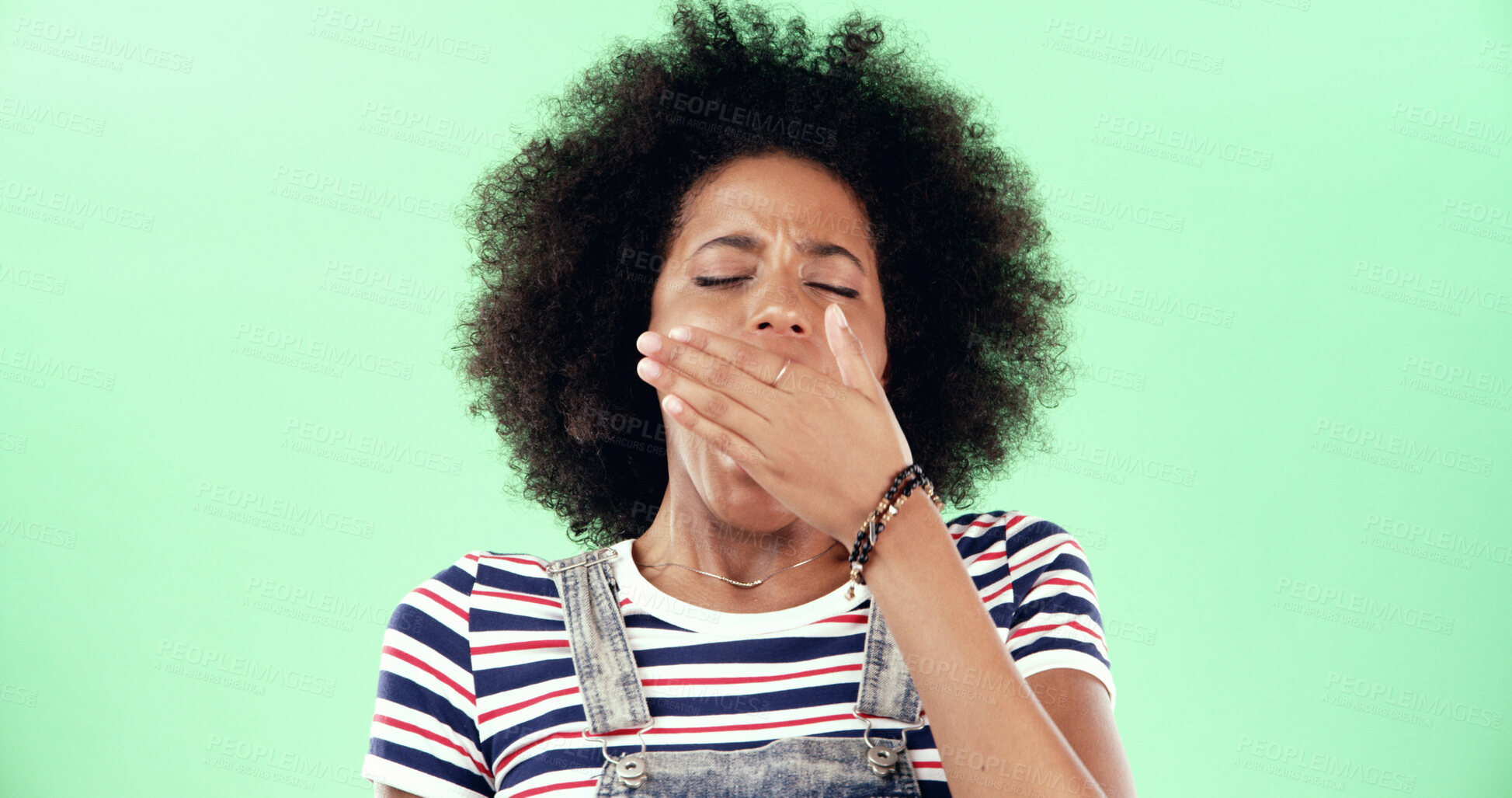 Buy stock photo Black woman, hand and yawning for fatigue in studio, sleepless or insomnia with gesture on green background. Low energy, tired or exhausted with female person covering mouth for burnout or laziness