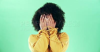 Buy stock photo Hands, covering and a shy woman in studio with embarrassment, mistake or disappointed emotion. Person, shame and hiding identity while scared, sad or afraid with body language on green background
