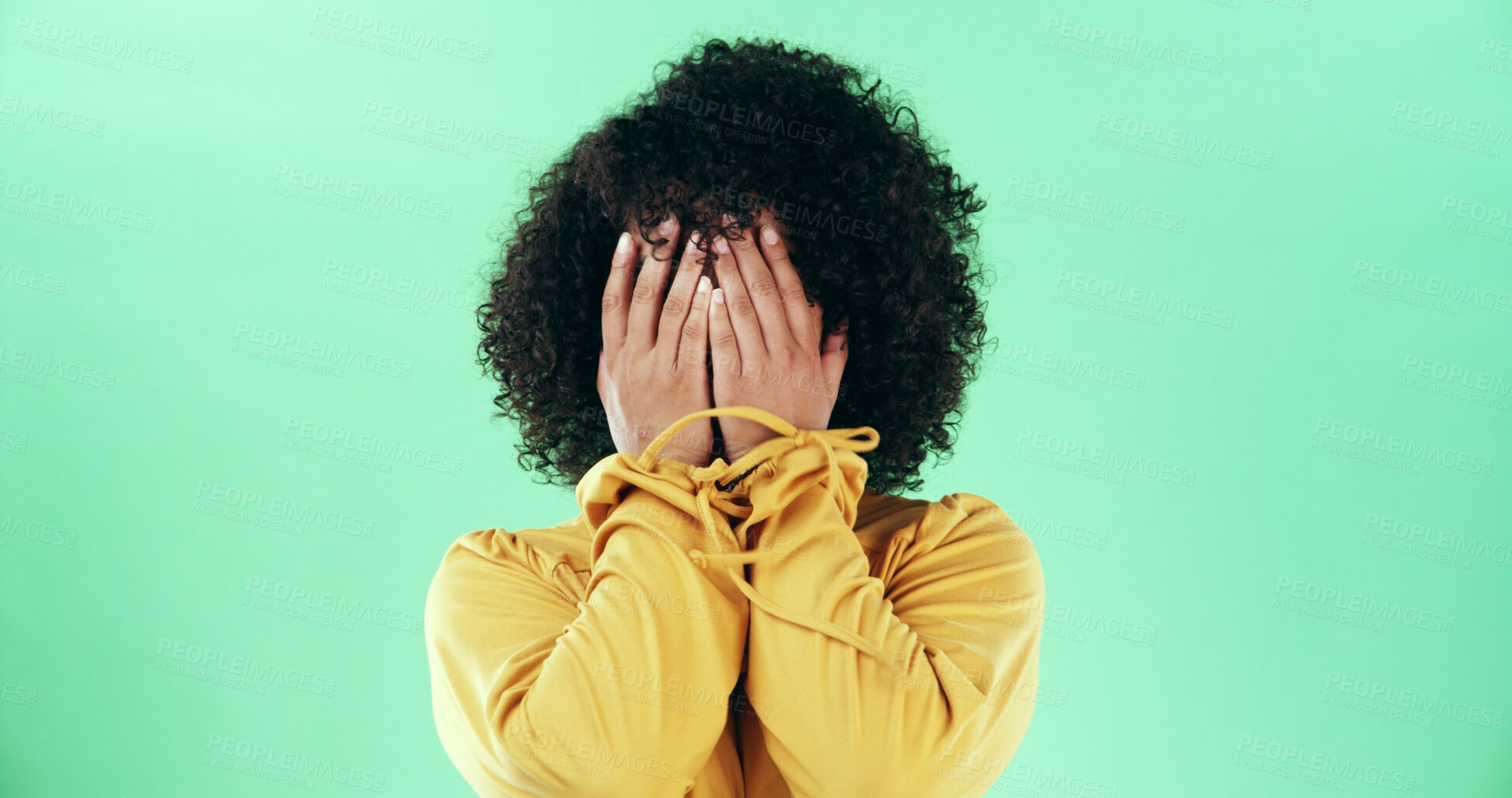 Buy stock photo Hands, covering and a shy woman in studio with embarrassment, mistake or disappointed emotion. Person, shame and hiding identity while scared, sad or afraid with body language on green background