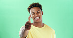 Smile, thumbs up and black man in studio with yes, thank you and winning hand sign on green background. Agree, face and model isolated with gesture for support, success approval or good job emoji