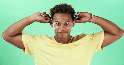 Buy stock photo Silly, funny face and smile with black man on green background in studio for humor, joke and meme. Portrait, crazy and comedy with happy African student, model and playful with goofy expression
