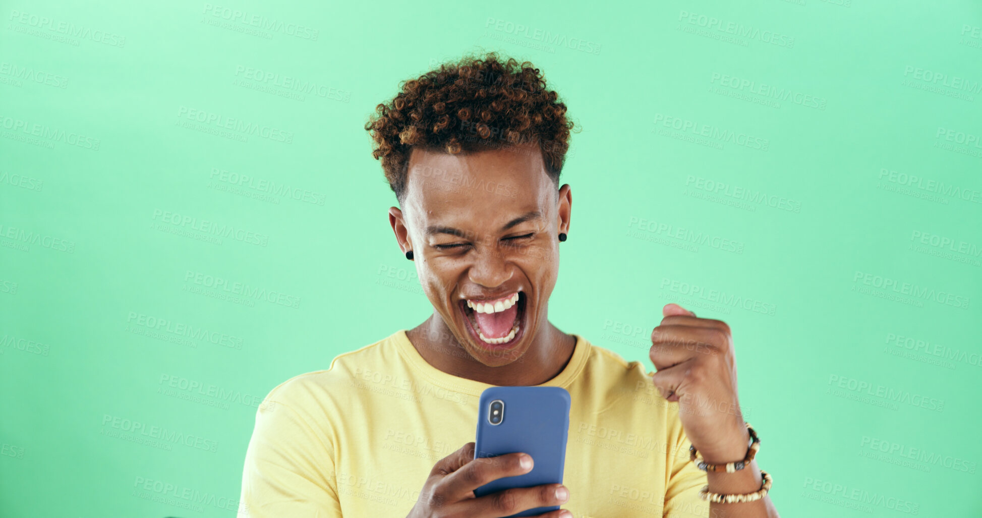 Buy stock photo Black man, phone and celebration in studio with fist pump, success and win online prize by green background. African person, smartphone and mobile app with goals, profit and mockup space with trading