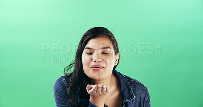 Buy stock photo Woman, gesture and blowing kiss in studio for flirting, show attraction and romance icon. Mockup space, female person and smile with love emoji for valentines day, affection sign and green background