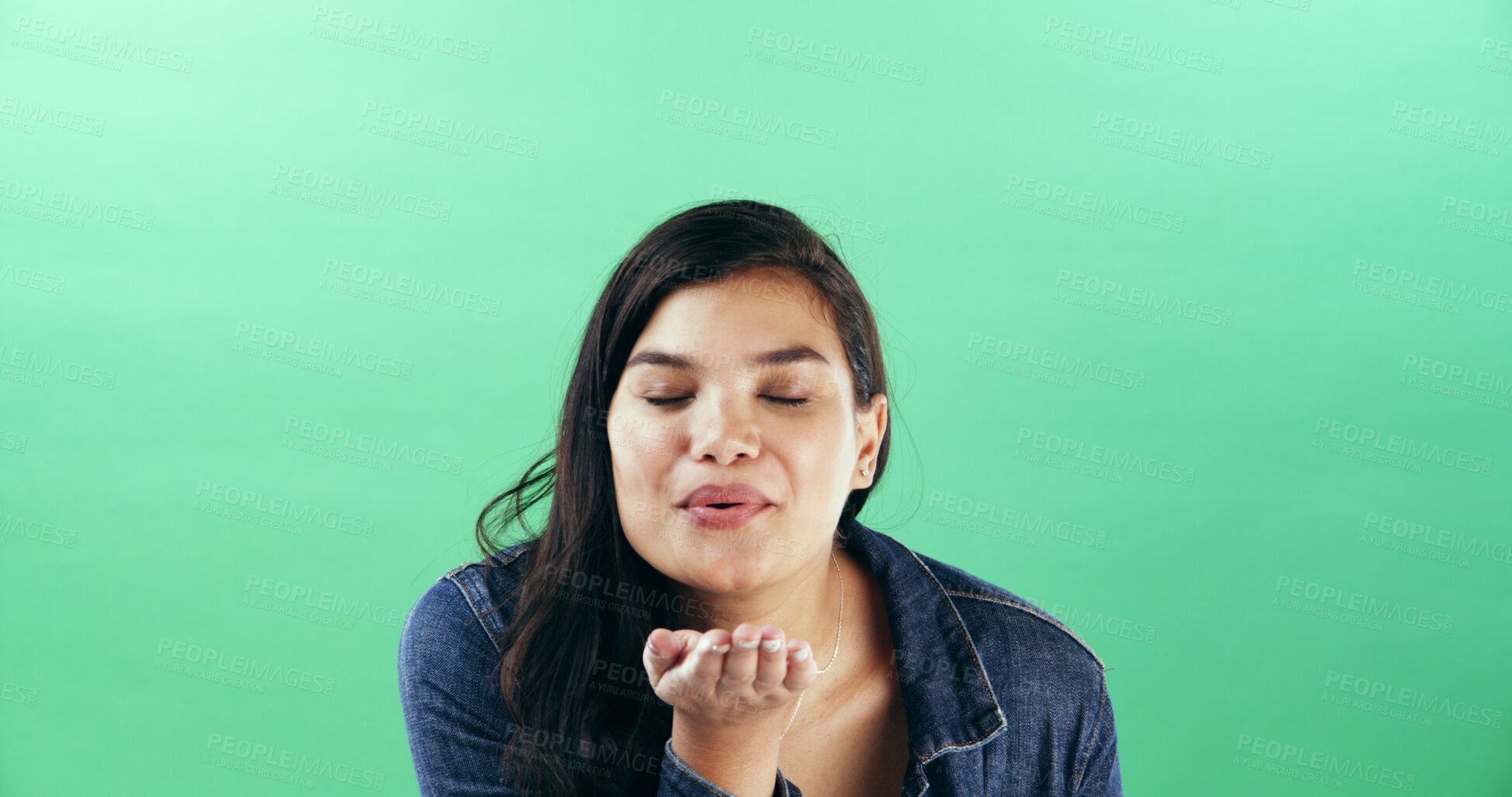 Buy stock photo Woman, gesture and blowing kiss in studio for flirting, show attraction and romance icon. Mockup space, female person and smile with love emoji for valentines day, affection sign and green background