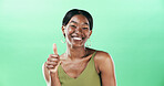 Black woman, thumbs up and portrait with smile for support in studio, vote or review with gesture on green background. Hand, yes sign or signal with emoji, female person and feedback by space