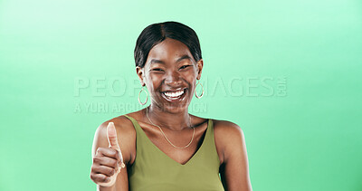 Buy stock photo Woman, thumbs up and portrait with happiness for support in studio, vote or review with gesture. Hand, yes sign or signal with emoji, African female person and feedback by space on green background