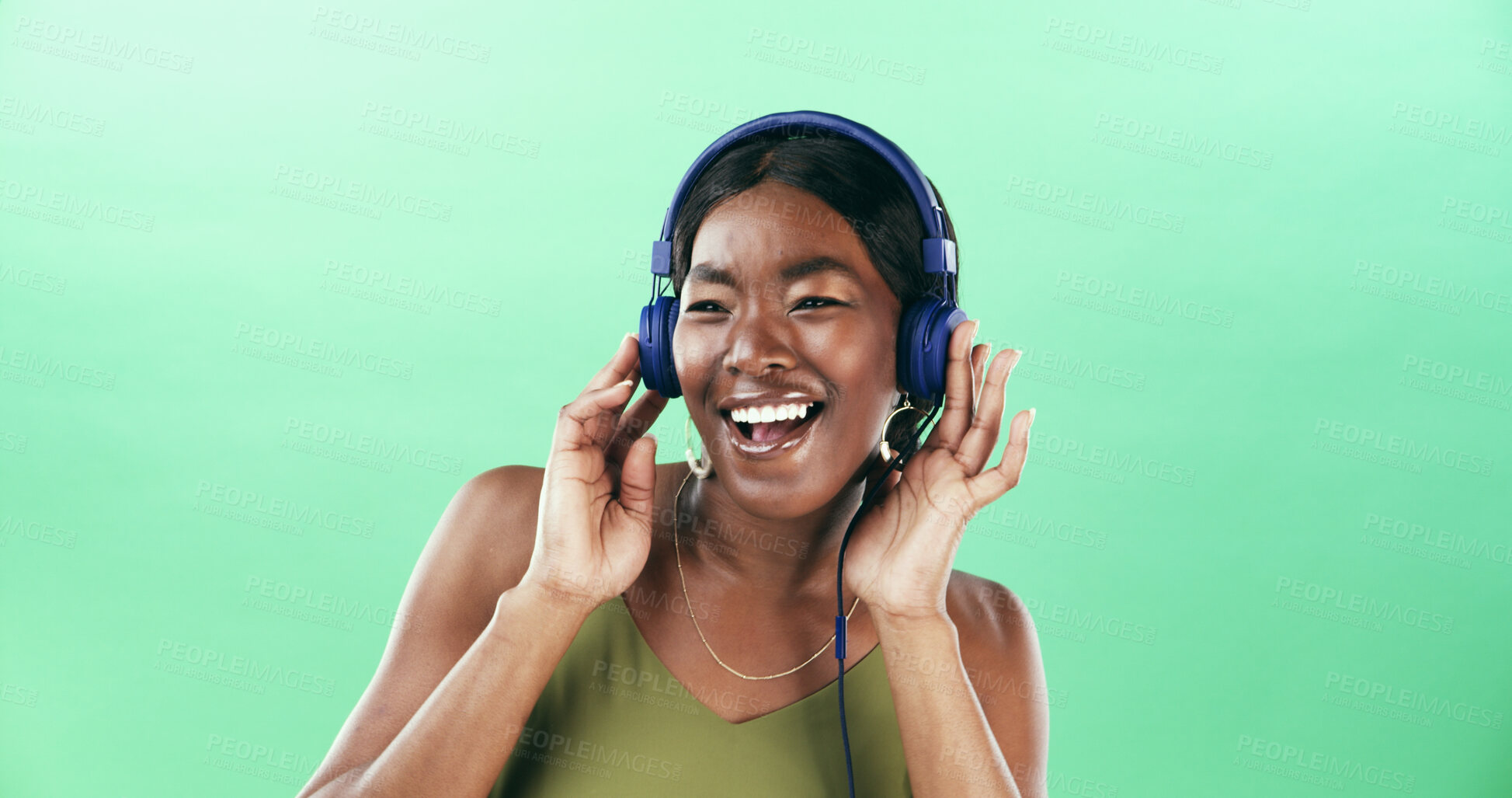 Buy stock photo Music, smile and headphones with black woman in studio for streaming, audio playlist and song. Performance, sound and dancing with female person on green background for entertainment and space