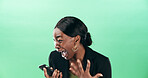 Excited, black woman and screaming with phone for good news or winning on a green studio background. Female person, employee or winner shouting with surprise on mobile smartphone for bonus promotion