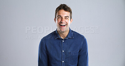 Buy stock photo Portrait, humor and man in studio, smile and laughing with positive mindset on gray background space. Face, happy person or model with confident personality, joke and funny with comic or fun attitude