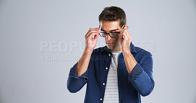 Buy stock photo Man, glasses and optometry in studio for testing, vision or adjusting to new lens for sight. Person, prescription specs and touch on white background space for eye care, designer frames or healthcare