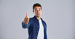 Man, portrait or thumbs up in studio for okay. good job or well done on a gray background. Male person, model or hand gesture with like emoji or yes sign for thank you or agreement on mockup space