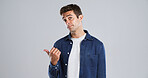 Pointing, mockup space and portrait of man in studio with decision, opinion or news announcement. Choice, direction and male person from London with presentation hand gesture by white background.