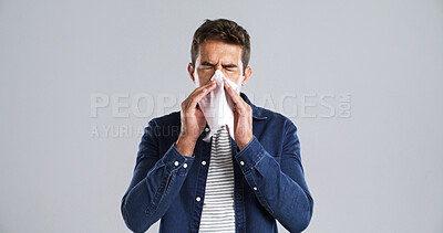 Buy stock photo Sick man, sneeze and blowing nose with tissue in studio for cold, flu or sinus on white background. Male person, model or influenza with cough or allergy for hayfever or illness on mockup space