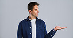 Advertising, man and palm with presentation in studio for offer deal, promotion and announcement. Launch, ambassador and show marketing space for about us, coming soon or sale news on gray background