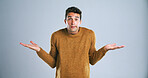 Confused, portrait and shrugging with man in studio for doubt, problem solving or question. Emoji, hand gesture and solution with unsure person on white background for answer, decision or mistake