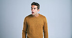 Scared, man and shocked with fear in studio for bad news, drama and reaction for danger risk. Mockup space, person and surprise expression for horror story, scary rumor and terror on gray background