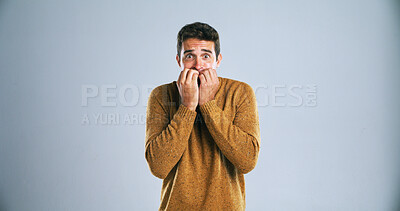 Buy stock photo Nervous, portrait or man with nail bite in studio for anxiety, fear or stress on a white background. Scared, male person or model in terror for mental health, overwhelmed or intense on mockup space