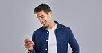 Smile, phone and man in studio for social media, text or reading message on white background space. Mobile, happy person and check email online on app for communication, news or blog post on internet