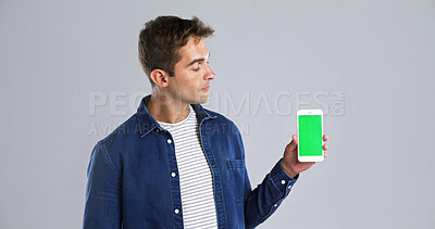 Buy stock photo Man, hand and phone with green screen in studio for advertising on white background. Male person, model or user with mobile smartphone display, chromakey or new app for marketing on mockup space