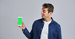 Man, advertising or phone with green screen in studio for new app on a white background. Male person, model or user with mobile smartphone display, chromakey or UX for marketing or UI on mockup space