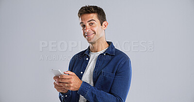 Buy stock photo Portrait, happy man and typing with mobile in studio for social media or text on white background. Phone, smile and person with message on app for download, network and blog post with mockup space