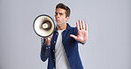 Portrait, bullhorn and man with stop, angry or frustrated with protest on white studio background. Hand gesture, person or model with megaphone, social justice or activism for human rights or freedom