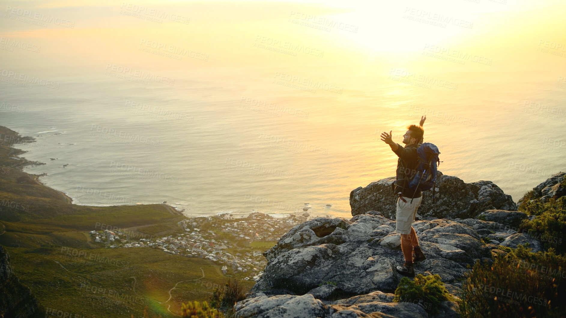 Buy stock photo Ocean, mountains and man with arms raised, nature and excited with fitness, challenge or break. Environment, hiker and person with happiness, exercise or seaside with energy, celebrate or achievement