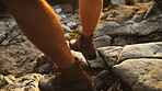Legs, person and hiking by rocks for travel, vacation and holiday on adventure in nature. Walking, shoes and hiker trekking on mountain for exploration, tourism and journey for hobby with top view