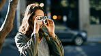 Camera, travel and woman in city for sightseeing on vacation, getaway or weekend trip with photography. Equipment, tourist and female person capturing view for social media in urban town for holiday.