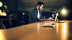 Desk, laptop and night with business man in office for deadline or feedback on creative report. Computer, research and typing with design employee in dark workplace for productivity at zero hour