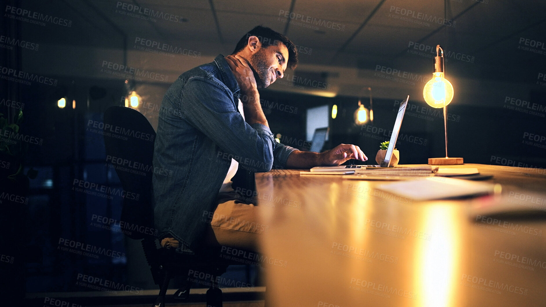 Buy stock photo Neck pain, night and man in office with injury for working late on project, deadline and software. Professional, IT technician and person on laptop with stress, strain and muscle fatigue for posture