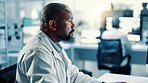 Innovation, medical and science with black man in laboratory for online development or research. Computer, healthcare and reading with scientist at desk for breakthrough, clinical trial or experiment
