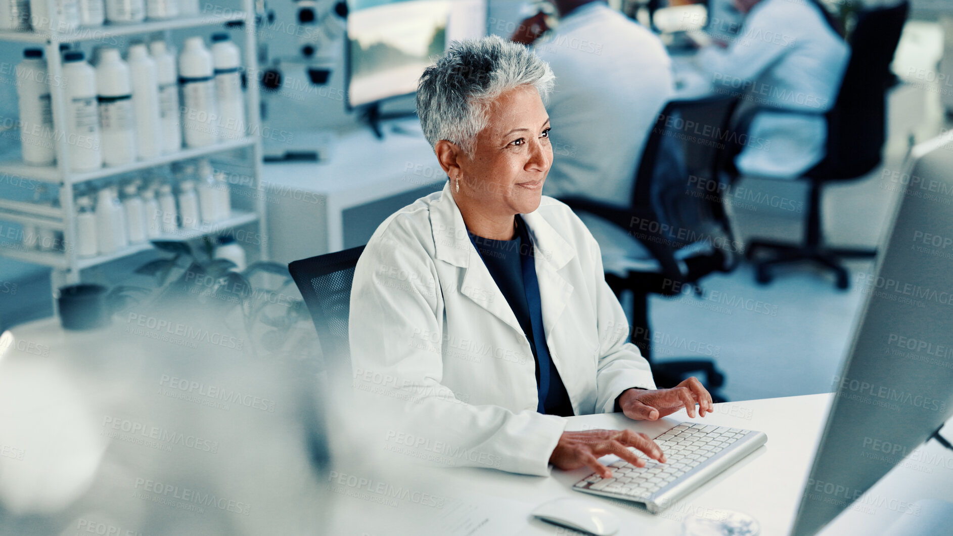 Buy stock photo Computer, medical and science with woman in laboratory for online development or research. Innovation, smile and typing with mature scientist at desk for breakthrough, clinical trial or experiment