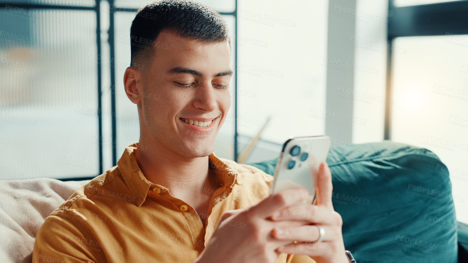 Buy stock photo Phone, relax and weekend with man on sofa in living room of home for break or internet browsing. App, social media and text message with happy person in apartment for communication or search