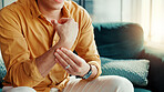 Home, wrist pain and man on sofa, hands or inflammation with stress, strain or pressure. Apartment, closeup or person on couch, arthritis or carpal tunnel syndrome with joint injury or muscle tension