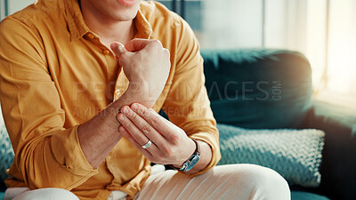 Buy stock photo Home, wrist pain and man on sofa, hands or inflammation with stress, strain or pressure. Apartment, closeup or person on couch, arthritis or carpal tunnel syndrome with joint injury or muscle tension