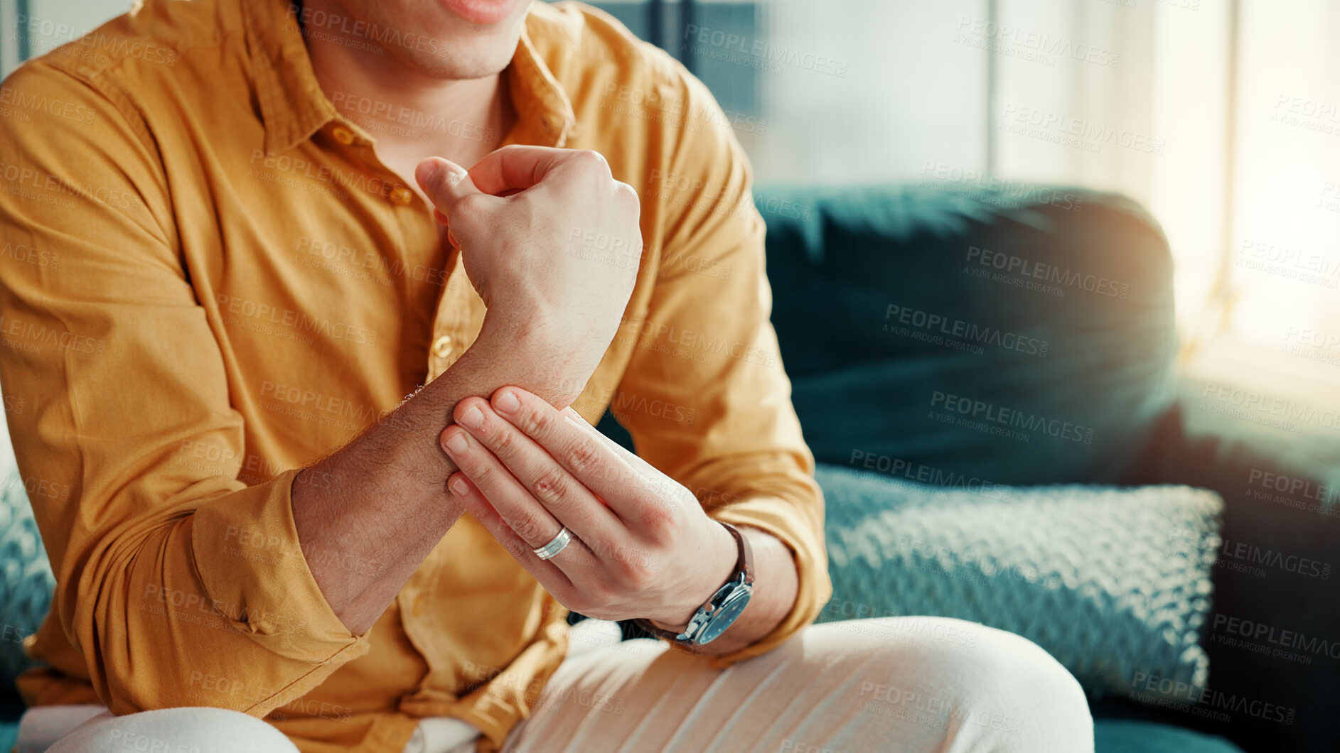 Buy stock photo Home, wrist pain and man on sofa, hands or inflammation with stress, strain or pressure. Apartment, closeup or person on couch, arthritis or carpal tunnel syndrome with joint injury or muscle tension
