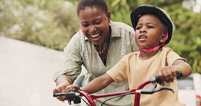 Buy stock photo Support, teaching and boy on bicycle with mom on street of neighborhood for child development. African woman, smile or black kid with trust, help or single mother to learn how to ride bike outside