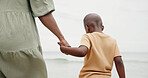 Holding hands, parent and boy at beach on vacation with care, love and bonding in nature. Person, child and support with connection, outdoor and holiday for family with back, ocean and getaway by sea