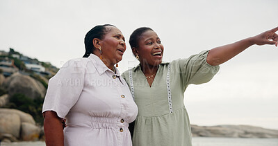 Buy stock photo Pointing, mother or black woman on beach for travel, holiday adventure and family trip. Outdoor, African parent and mature mom with daughter at sea for tropical vacation, love or sightseeing together