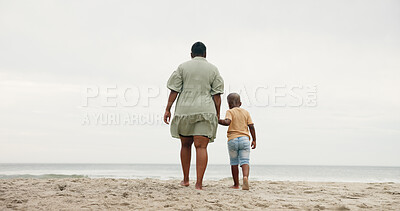 Buy stock photo Mother, boy and holding hands with back at beach, space and sky with bonding, care and vacation. Woman, child and outdoor on holiday with love, family and support with walk by ocean in Nigeria