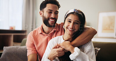 Buy stock photo Hug, couple and love in living room with smile, bonding and communication on sofa in apartment. Embrace, man and woman with portrait in house for relationship, support and relax in home lounge