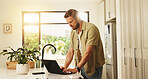 Typing, laptop and man in kitchen, home and planning for blog on social media, website and creative. Apartment, writer and person with tech for post on streaming site, blogger or remote work in house