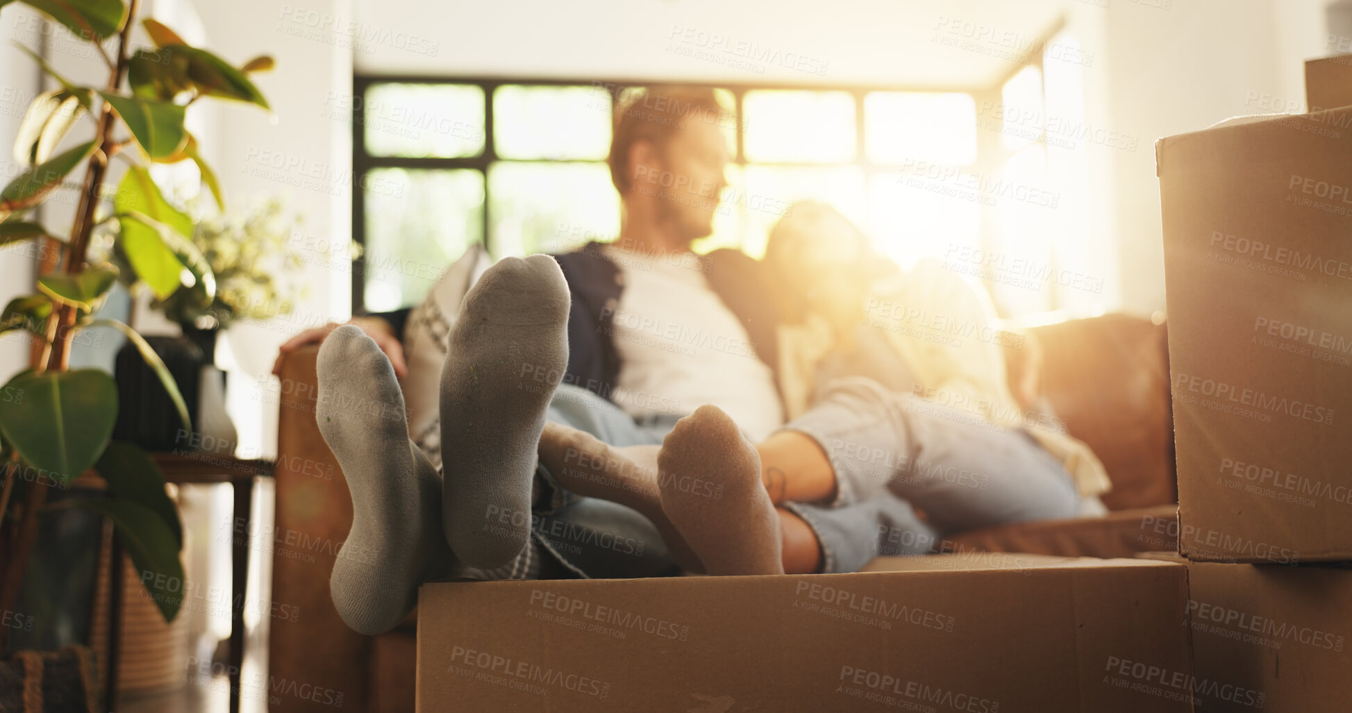 Buy stock photo Couple, relax and couch with boxes at new house for relocation, investment and bonding together. People, lens flare and sofa for moving property, loan success and security for accommodation ownership