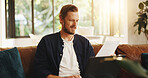 Man, paper and reading on sofa with laptop, writer and thinking for script draft in home. Person, editor and technology in living room for research, networking and application with freelancer