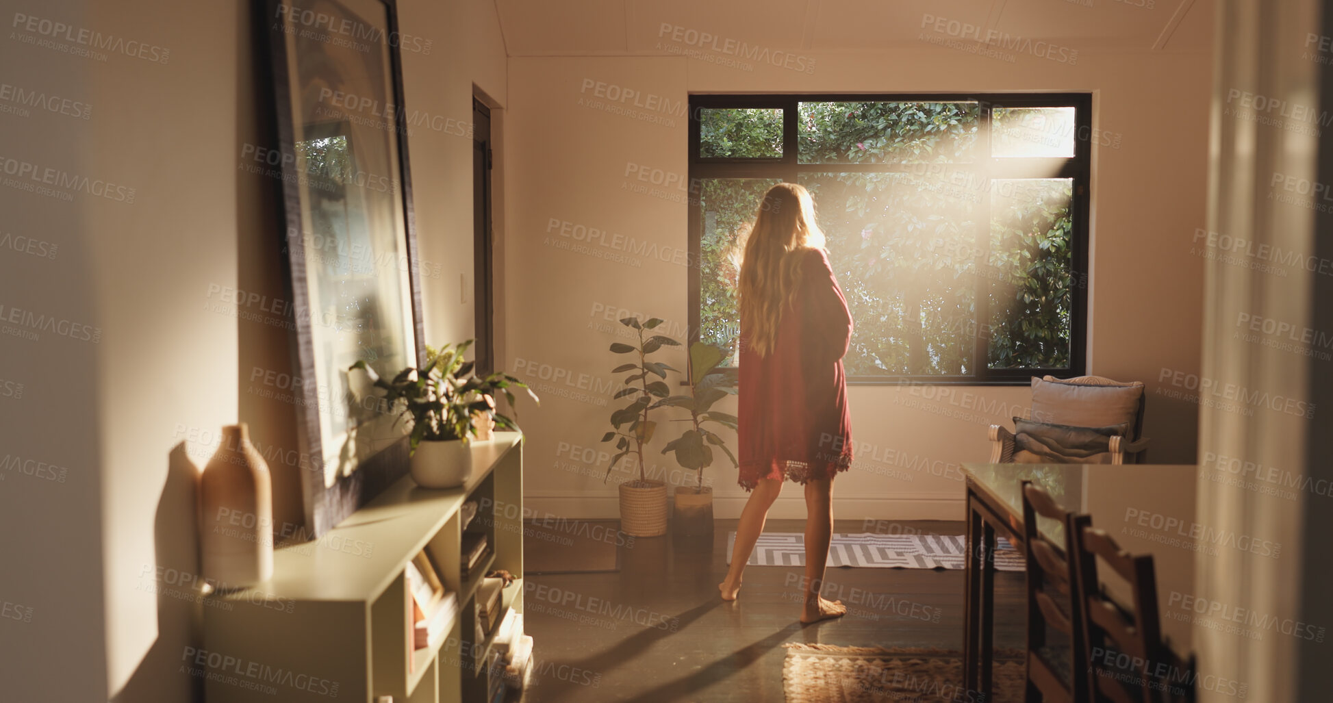 Buy stock photo Back, sunshine and woman by window for thinking, vision or ready to start day in home. House, good morning and person with view, flare and reflection while daydreaming on weekend with peace or calm