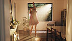 Back, woman and stretching by window for good morning, freedom and ready to start day in house. Home, sunshine and person with view for wake up, flare and fresh with energy on weekend with peace