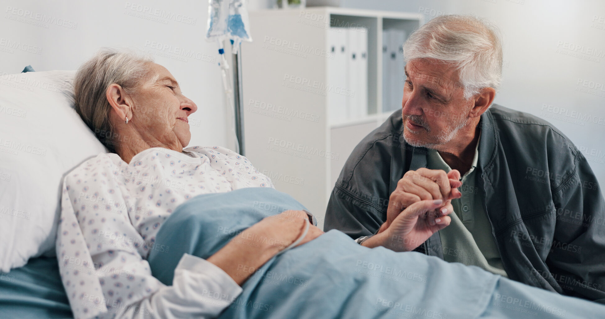 Buy stock photo Love, holding hands and healthcare with old couple in hospital for ICU recovery, support and comfort. Medical, empathy and trust with senior man and patient in clinic for treatment, diagnosis or care