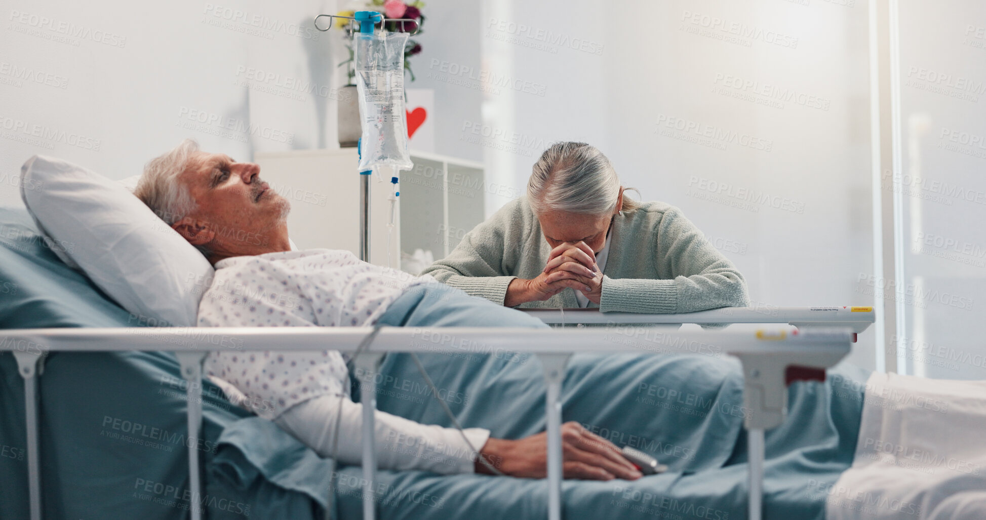 Buy stock photo Senior woman, man and praying by hospital bed for faith, love or hope for healing in retirement. Elderly people, couple and religion for wellness, visit and sick patient for rehabilitation at clinic