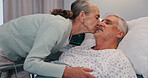 Senior woman, man and kiss in hospital bed for care, love or support for healing in retirement. Elderly people, couple and kindness for trust, loyalty and visit patient for rehabilitation at clinic